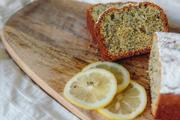 Tårta med vallmofrön och citron Zest, bevattnas med strös ocker. Cupcake med citron på en träskiva. — Stockfoto