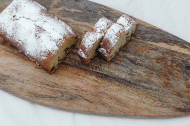 Kuru üzümlü kek, pudra şekeri ile tozlanmış. Ahşap bir tahta üzerinde kuru üzüm ile Cupcake.