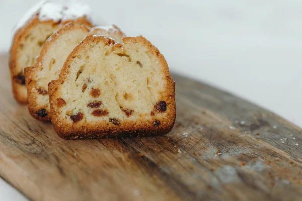 Kuru üzümlü kek, pudra şekeri ile tozlanmış. Ahşap bir tahta üzerinde kuru üzüm ile Cupcake.