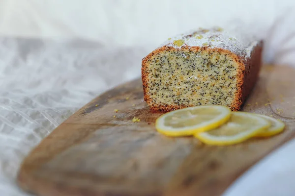 Tårta med vallmofrön och citron Zest, bevattnas med strös ocker. Cupcake med citron på en träskiva. — Stockfoto