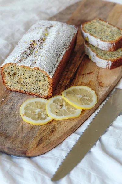 Tårta med vallmofrön och citron Zest, bevattnas med strös ocker. Cupcake med citron på en träskiva. — Stockfoto