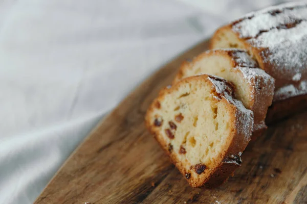 Raisin tårta, dammas med florsocker. Cupcake med russin på en träskiva. — Stockfoto