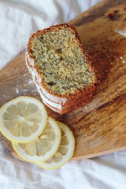 Haşhaş tohumları ve limon suyu ile kek, pudra şekeri serpilir. Ahşap tahta üzerinde limon ile Cupcake.