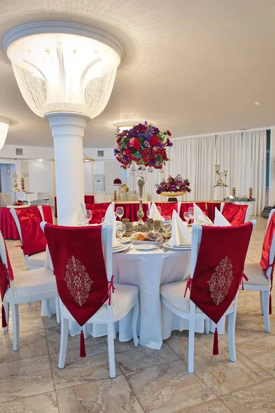 Design of a banquet hall, decoration of chairs. Festive table setting, serving.