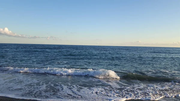 美しい青い海 小さな波とシュメールの日で Horizzon に隠された沈む夕日の素晴らしいキャプション — ストック写真