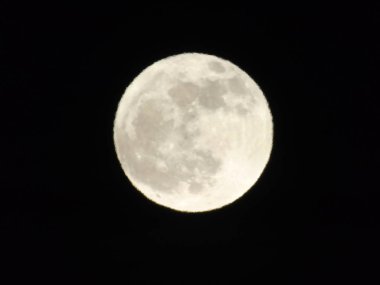 Geceleyin Cenova şehrinin üzerinde muhteşem bir dolunay fotoğrafı. Arka planda harika bir gökyüzü ve bazı yıldızlar var.