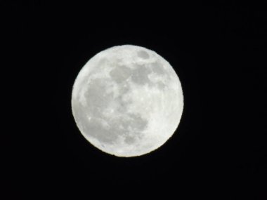 Geceleyin Cenova şehrinin üzerinde muhteşem bir dolunay fotoğrafı. Arka planda harika bir gökyüzü ve bazı yıldızlar var.