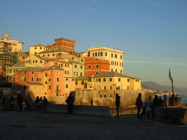 ジェノヴァ イタリア 2019 冬の日と太陽の光で色ビーチ近くの古い建物の素晴らしい景色のいくつかの波とジェノバの街で海に沈む夕日の素晴らしいキャプション — ストック写真