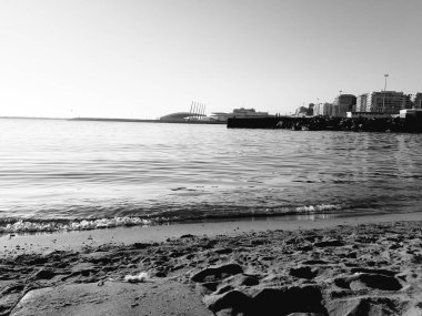 Genova, İtalya - 02/25/2019: bazı dalgalar ve Cenova şehir denize sıfır üzerinden günbatımı kış gün ve güneş tarafından renkli plaja yakın eski binalar için harika manzarası inanılmaz bir resim yazısı