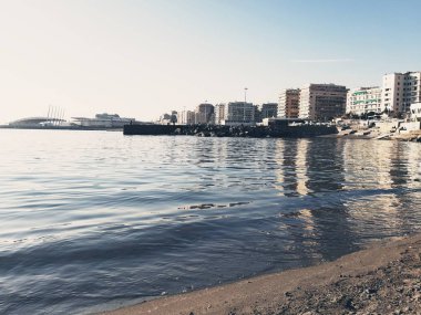 Genova, İtalya - 02/25/2019: bazı dalgalar ve Cenova şehir denize sıfır üzerinden günbatımı kış gün ve güneş tarafından renkli plaja yakın eski binalar için harika manzarası inanılmaz bir resim yazısı