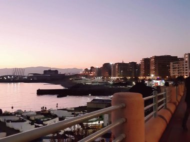 Genova, İtalya - 02/25/2019: bazı dalgalar ve Cenova şehir denize sıfır üzerinden günbatımı kış gün ve güneş tarafından renkli plaja yakın eski binalar için harika manzarası inanılmaz bir resim yazısı