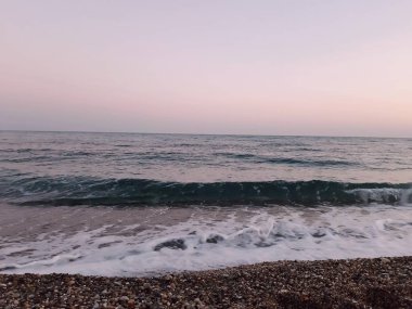 Genova, İtalya - 02/25/2019: bazı dalgalar ve Cenova şehir denize sıfır üzerinden günbatımı kış gün ve güneş tarafından renkli plaja yakın eski binalar için harika manzarası inanılmaz bir resim yazısı