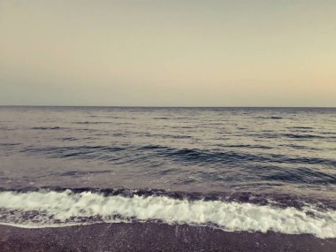 Genova, İtalya - 02/25/2019: bazı dalgalar ve Cenova şehir denize sıfır üzerinden günbatımı kış gün ve güneş tarafından renkli plaja yakın eski binalar için harika manzarası inanılmaz bir resim yazısı