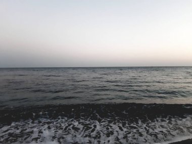 Genova, İtalya - 02/25/2019: bazı dalgalar ve Cenova şehir denize sıfır üzerinden günbatımı kış gün ve güneş tarafından renkli plaja yakın eski binalar için harika manzarası inanılmaz bir resim yazısı