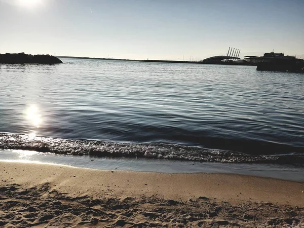 Genova, İtalya - 02/25/2019: bazı dalgalar ve Cenova şehir denize sıfır üzerinden günbatımı kış gün ve güneş tarafından renkli plaja yakın eski binalar için harika manzarası inanılmaz bir resim yazısı