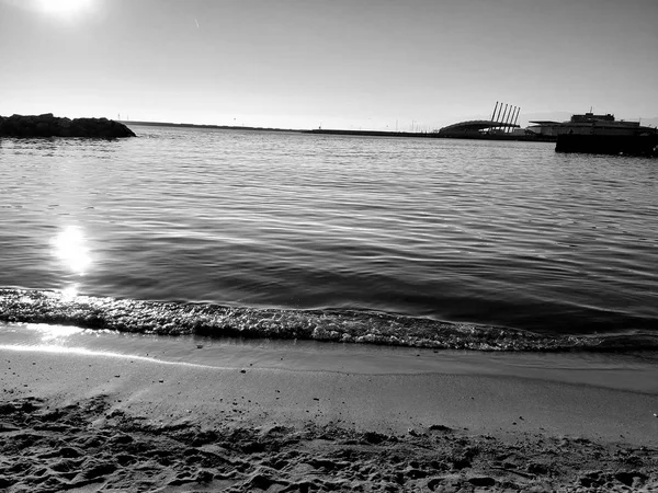 Genova, İtalya - 02/25/2019: bazı dalgalar ve Cenova şehir denize sıfır üzerinden günbatımı kış gün ve güneş tarafından renkli plaja yakın eski binalar için harika manzarası inanılmaz bir resim yazısı