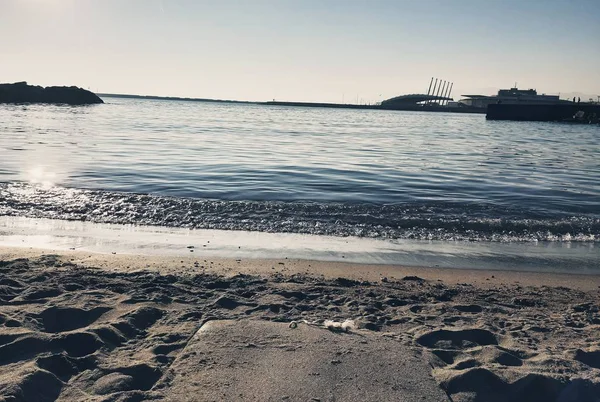 Genova, İtalya - 02/25/2019: bazı dalgalar ve Cenova şehir denize sıfır üzerinden günbatımı kış gün ve güneş tarafından renkli plaja yakın eski binalar için harika manzarası inanılmaz bir resim yazısı