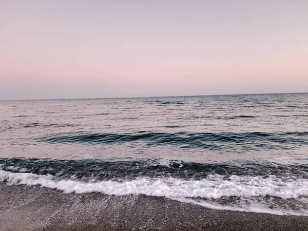 Genova, İtalya - 02/25/2019: bazı dalgalar ve Cenova şehir denize sıfır üzerinden günbatımı kış gün ve güneş tarafından renkli plaja yakın eski binalar için harika manzarası inanılmaz bir resim yazısı