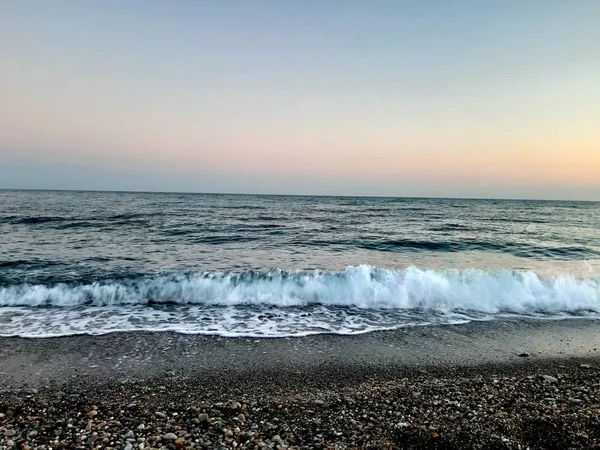 Genova, İtalya - 02/25/2019: bazı dalgalar ve Cenova şehir denize sıfır üzerinden günbatımı kış gün ve güneş tarafından renkli plaja yakın eski binalar için harika manzarası inanılmaz bir resim yazısı