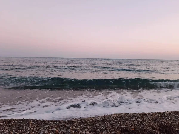 Genova, İtalya - 02/25/2019: bazı dalgalar ve Cenova şehir denize sıfır üzerinden günbatımı kış gün ve güneş tarafından renkli plaja yakın eski binalar için harika manzarası inanılmaz bir resim yazısı