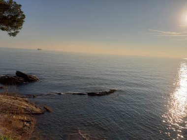 Küçük dalgalar ve kış günlerinde deniz ve bazı renkli bulutlar üzerinde inanılmaz bir yansıması ile güzel gün batımı harika bir resim yazısı