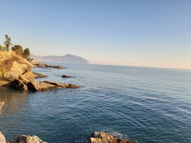 Küçük dalgalar ve kış günlerinde deniz ve bazı renkli bulutlar üzerinde inanılmaz bir yansıması ile güzel gün batımı harika bir resim yazısı
