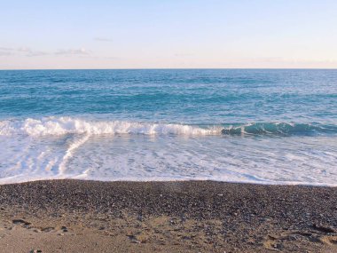 Genova, İtalya - 03/08/2019: küçük dalgalar ve kış yaşam ve bazı siyah-beyaz fotoğraflar deniz ve bazı renkli bulutlar üzerinde inanılmaz bir yansıması ile güzel gün batımı harika bir resim yazısı.