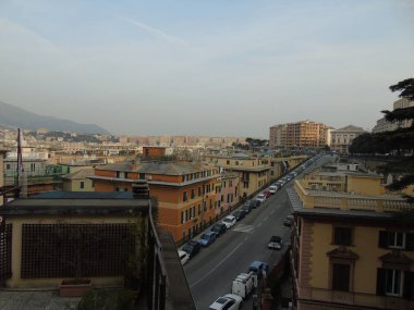 Genova, Italya-04/02/2019: büyük bir gri gökyüzü, bazı uzun gökdelenler ve güzel eski binalar ile, kış günlerinde tepelerden Genova kentinin inanılmaz bir başlık