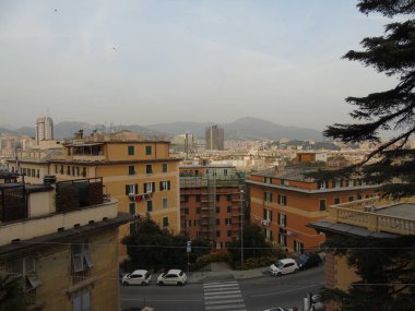 Genova, Italya-04/02/2019: büyük bir gri gökyüzü, bazı uzun gökdelenler ve güzel eski binalar ile, kış günlerinde tepelerden Genova kentinin inanılmaz bir başlık