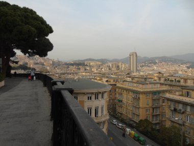 Genova, Italya-04/02/2019: büyük bir gri gökyüzü, bazı uzun gökdelenler ve güzel eski binalar ile, kış günlerinde tepelerden Genova kentinin inanılmaz bir başlık