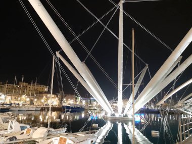 Genova, Italya-04/07/2019: bahar günlerinde gece Genova limanının inanılmaz bir başlık. Gece zevk bazı insanlar ile sahil üzerinde modern yapının güzel vieews.