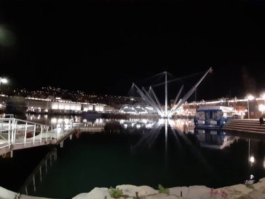 Genova, Italya-04/07/2019: bahar günlerinde gece Genova limanının inanılmaz bir başlık. Gece zevk bazı insanlar ile sahil üzerinde modern yapının güzel vieews.