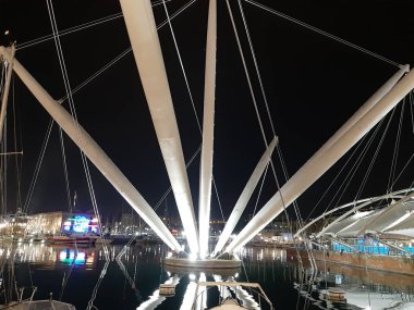 Genova, Italya-04/07/2019: bahar günlerinde gece Genova limanının inanılmaz bir başlık. Gece zevk bazı insanlar ile sahil üzerinde modern yapının güzel vieews.