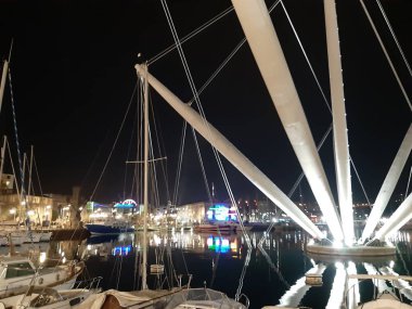 Genova, Italya-04/07/2019: bahar günlerinde gece Genova limanının inanılmaz bir başlık. Gece zevk bazı insanlar ile sahil üzerinde modern yapının güzel vieews.