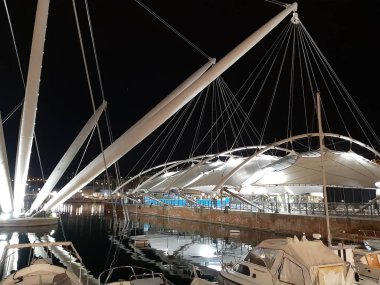 Genova, Italya-04/07/2019: bahar günlerinde gece Genova limanının inanılmaz bir başlık. Gece zevk bazı insanlar ile sahil üzerinde modern yapının güzel vieews.