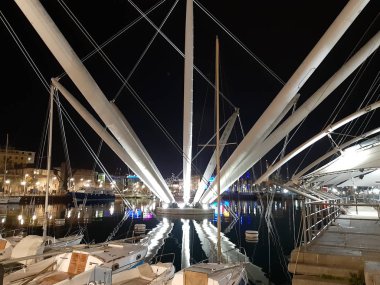 Genova, Italya-04/07/2019: bahar günlerinde gece Genova limanının inanılmaz bir başlık. Gece zevk bazı insanlar ile sahil üzerinde modern yapının güzel vieews.