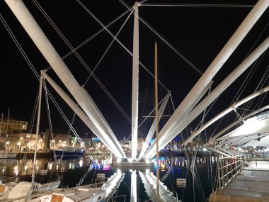 Genova, Italya-04/07/2019: bahar günlerinde gece Genova limanının inanılmaz bir başlık. Gece zevk bazı insanlar ile sahil üzerinde modern yapının güzel vieews.