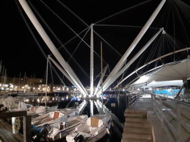 Genova, Italya-04/07/2019: bahar günlerinde gece Genova limanının inanılmaz bir başlık. Gece zevk bazı insanlar ile sahil üzerinde modern yapının güzel vieews.