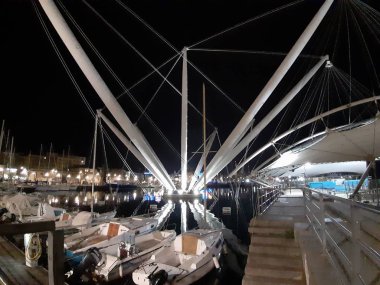 Genova, Italya-04/07/2019: bahar günlerinde gece Genova limanının inanılmaz bir başlık. Gece zevk bazı insanlar ile sahil üzerinde modern yapının güzel vieews.