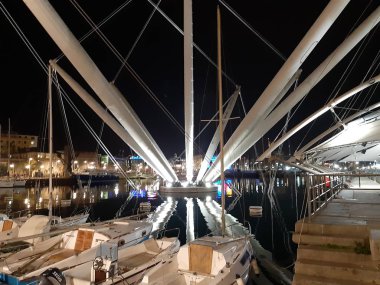 Genova, Italya-04/07/2019: bahar günlerinde gece Genova limanının inanılmaz bir başlık. Gece zevk bazı insanlar ile sahil üzerinde modern yapının güzel vieews.