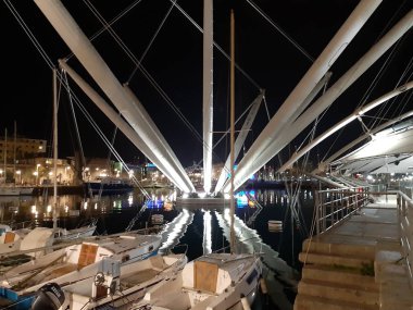 Genova, Italya-04/07/2019: bahar günlerinde gece Genova limanının inanılmaz bir başlık. Gece zevk bazı insanlar ile sahil üzerinde modern yapının güzel vieews.