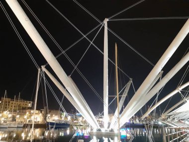 Genova, Italya-04/07/2019: bahar günlerinde gece Genova limanının inanılmaz bir başlık. Gece zevk bazı insanlar ile sahil üzerinde modern yapının güzel vieews.