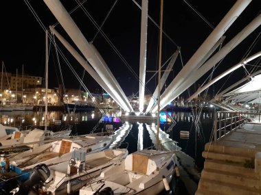 Genova, Italya-04/07/2019: bahar günlerinde gece Genova limanının inanılmaz bir başlık. Gece zevk bazı insanlar ile sahil üzerinde modern yapının güzel vieews.