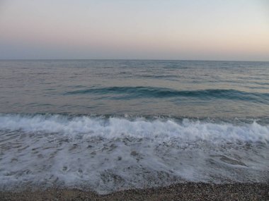 Genova, İtalya - 22.04.2019: Liguria, İtalya, Avrupa kıyılarında büyük dalgaların kırılması. Uçurumun üzerinde deniz inbeyaz dalgaları.