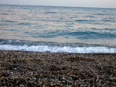 Genova, İtalya - 15.03.2019: Güzel kırmızı ve mavi gökyüzü, arka planda bazı şaşırtıcı bulutlar ve deniz üzerinde eski kayalar ile Genova denizi üzerinde bahar günlerinde gün batımı inanılmaz bir başlık.