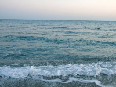 Genova, İtalya - 15.03.2019: Güzel kırmızı ve mavi gökyüzü, arka planda bazı şaşırtıcı bulutlar ve deniz üzerinde eski kayalar ile Genova denizi üzerinde bahar günlerinde gün batımı inanılmaz bir başlık.