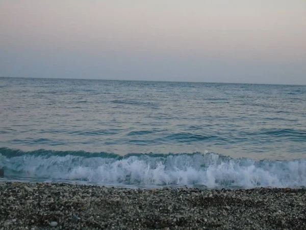 ジェノバ イタリア 2019 美しい赤と青の空とジェノバの海の上に春の日の夕日の素晴らしいキャプション 背景にいくつかの素晴らしい雲と海の上の古い岩 — ストック写真