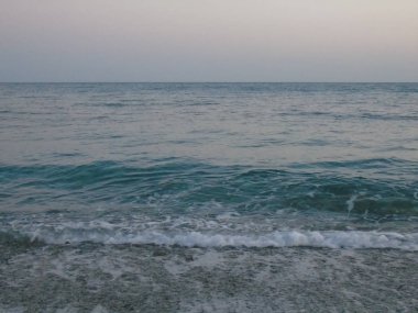 Genova, İtalya - 15.03.2019: Güzel kırmızı ve mavi gökyüzü, arka planda bazı şaşırtıcı bulutlar ve deniz üzerinde eski kayalar ile Genova denizi üzerinde bahar günlerinde gün batımı inanılmaz bir başlık.