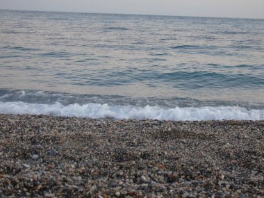 Genova, İtalya - 15.03.2019: Güzel kırmızı ve mavi gökyüzü, arka planda bazı şaşırtıcı bulutlar ve deniz üzerinde eski kayalar ile Genova denizi üzerinde bahar günlerinde gün batımı inanılmaz bir başlık.