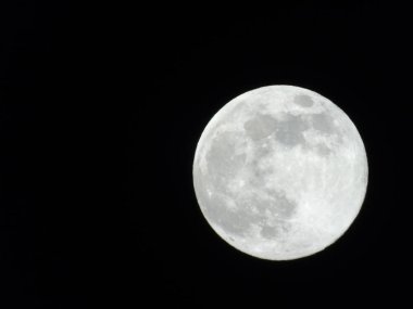 Arka planda büyük bir berrak ve mavi gökyüzü ve bazı yıldızlar ile gece Genova şehri üzerinde dolunay inanılmaz bir fotoğraf.